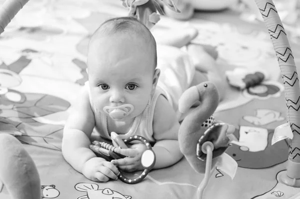 Baby op het speelgoed tapijt — Stockfoto