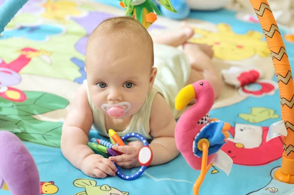 Bebé en la alfombra de juguete — Foto de Stock