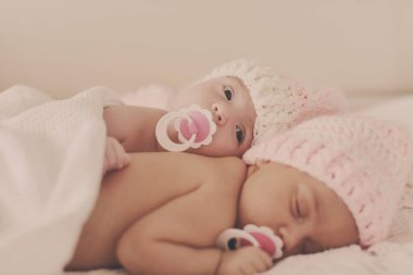 İki tatlı ikiz yatakta yatıyor.