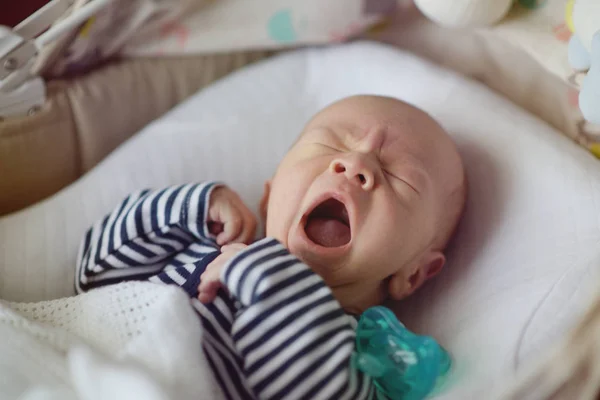 Haukottelu Vastasyntynyt Vauva Makaa Sängyssä — kuvapankkivalokuva