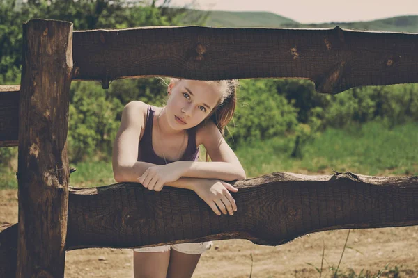 Teenie-Mädchen entspannt sich in der Nähe von Zaun — Stockfoto