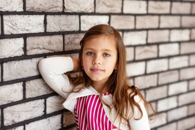 Duvarın yanındaki küçük şirin kızın portresi.