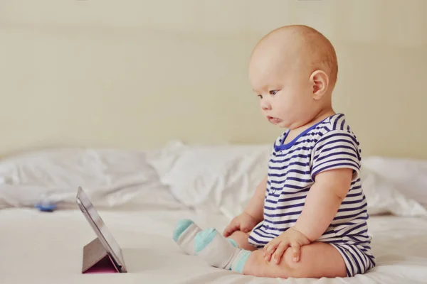 ベッドの上にタブレットPcを持っている赤ちゃん — ストック写真