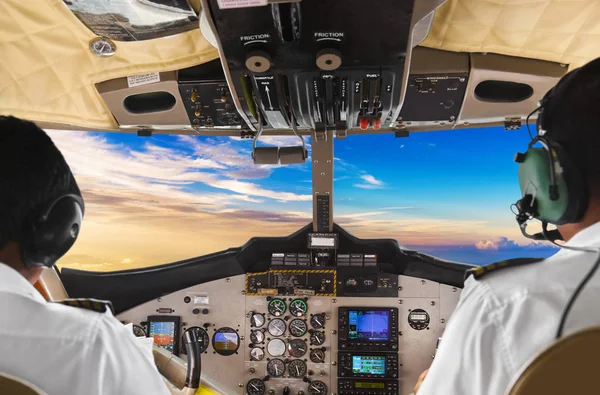Pilots in the plane cockpit and sunset — Stock Photo, Image