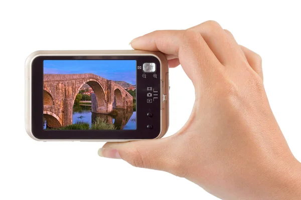 Hand with camera and Old bridge in Trebinje - Bosnia and Herzego — Stock Photo, Image