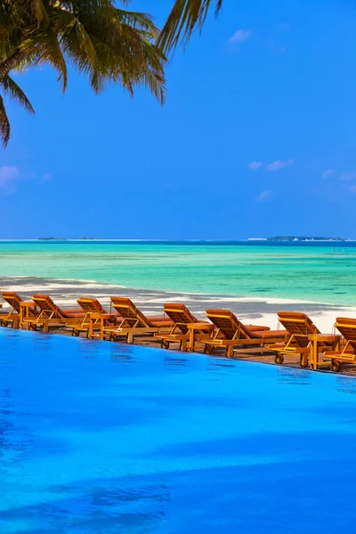 Espreguiçadeiras e piscina na praia das Maldivas — Fotografia de Stock