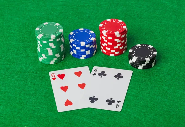Casino chips en speelkaarten op groene tafel — Stockfoto