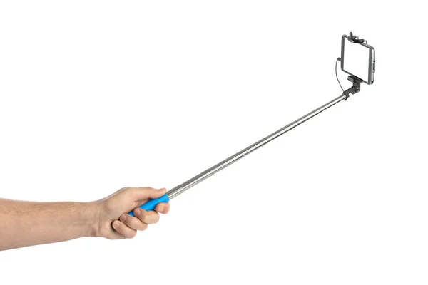 Ręka i smartfon z selfie stick — Zdjęcie stockowe