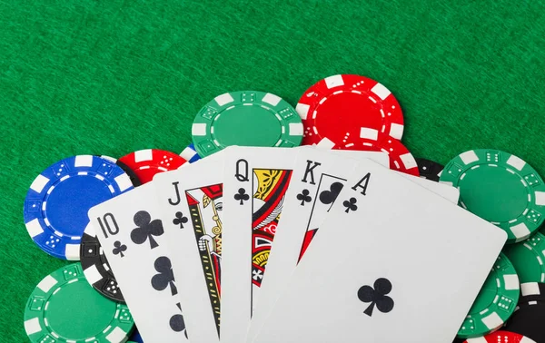 Casino chips en speelkaarten op groene tafel — Stockfoto