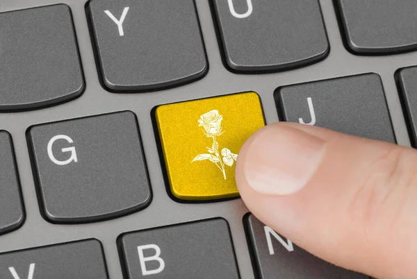 Computer keyboard with flower key - technology background