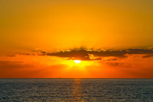 Oranje zonsondergang met stralen schijnt door de wolken in Paphos — Stockfoto