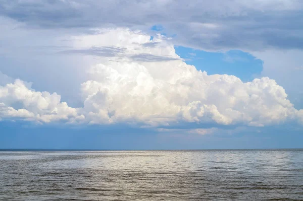 自然背景の上大きなふわふわ雲と大きな湖. — ストック写真