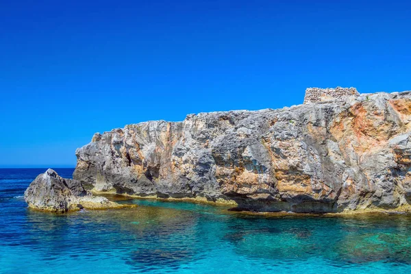 Klippe an der Südküste der Insel Menorca mit kleinen antiken Talayot. — Stockfoto