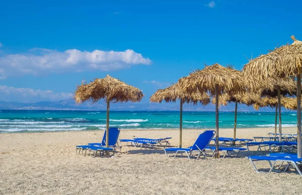 Chrisi (Chrysi) eiland strand achtergrond met stro parasols — Stockfoto