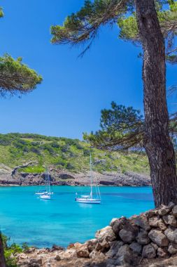 Güzel Menorca Island cove ile turkuaz üzerinde yüzen yatlar 