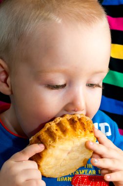 küçük çocuk dağınık yüzü ile taze bir krem fincan kek yeme