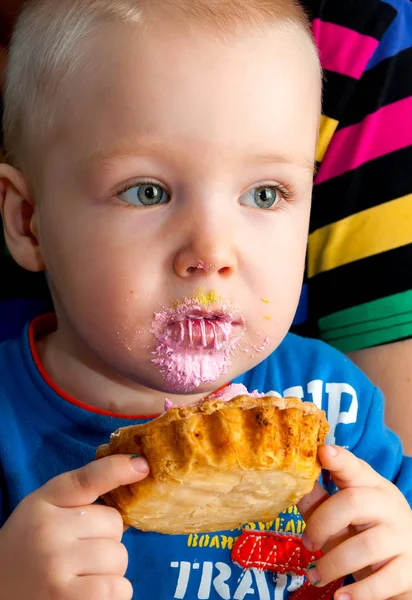 Niño pequeño comiendo un pastel de crema fresca taza con la cara desordenada — Foto de Stock