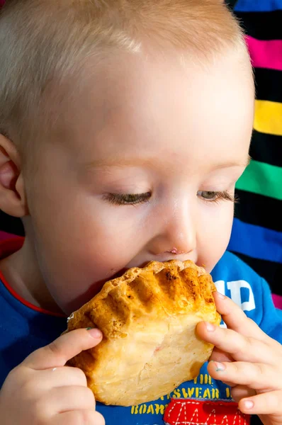 乱雑な顔で新鮮なクリームカップケーキを食べる小さな男の子 — ストック写真