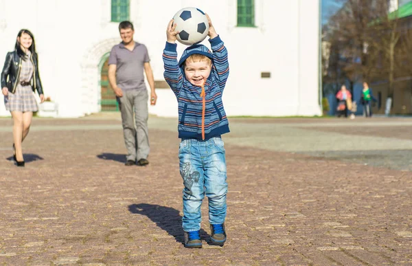 Bonito menino está andando em um parque com seus pais — Fotografia de Stock