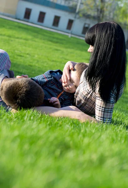 Unique perspective of two loving parents lying on the grass with their baby Stock Image