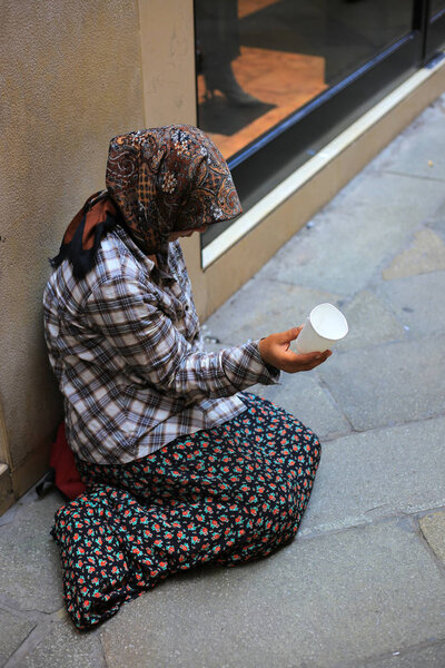 Elderly beggar woman on the street asking for money