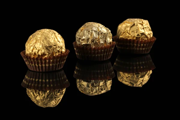 Goldverpackte Bonbons Auf Schwarz — Stockfoto
