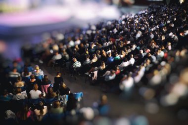 Bir sürü genç insan büyük bir salonda bir hoparlör dinleme