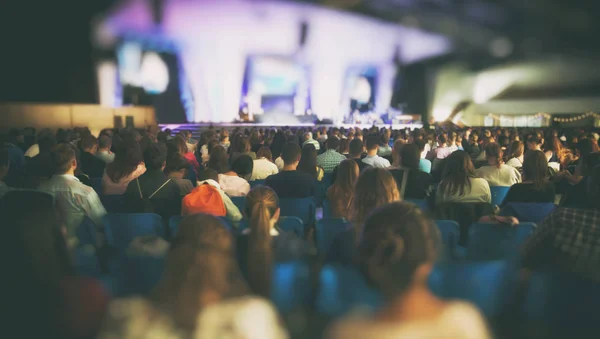A lot of young people in a big hall listening to a speaker — Stock Photo, Image