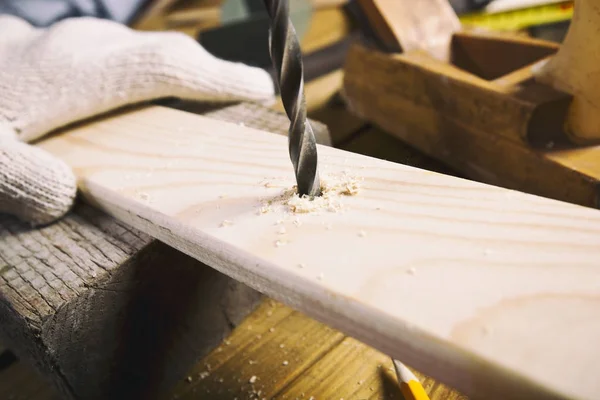Uomo trapana la tavola di legno — Foto Stock