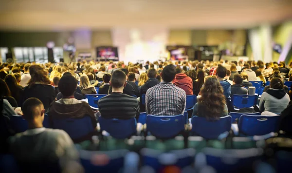 Mucha gente joven en un gran salón escuchando a un orador — Foto de Stock