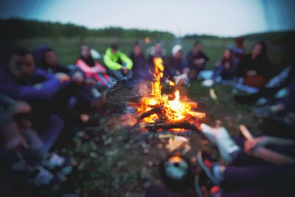 Friends are sitting around the bonfire — Stock Photo, Image