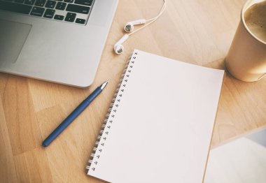 Not Defteri, dizüstü bilgisayar ve ahşap masa üzerinde kulaklık