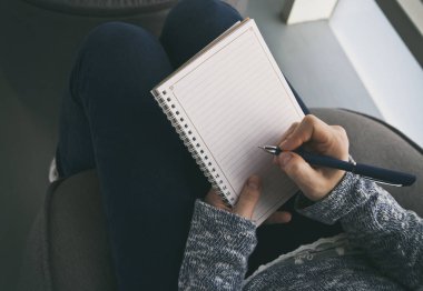 Kadın kağıt not defterinde yazıyor