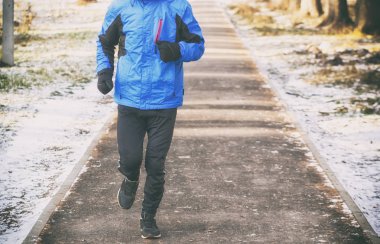 Genç adam kış parkta koşu