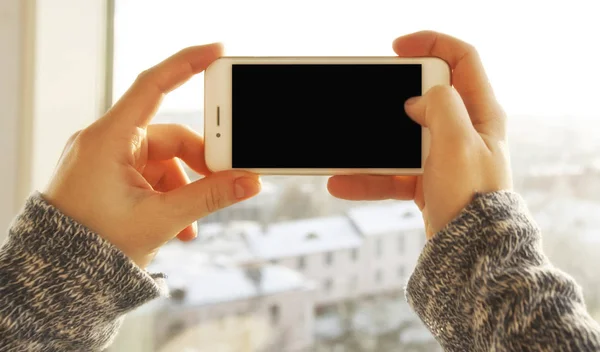 De jonge vrouw houdt een GSM met wit scherm — Stockfoto