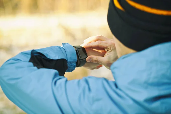 O homem está a olhar para os seus smartwatches — Fotografia de Stock