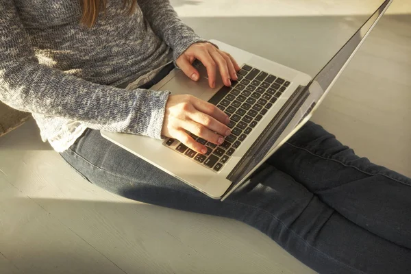 Młoda kobieta siedzi na podłodze i praca z laptopem — Zdjęcie stockowe