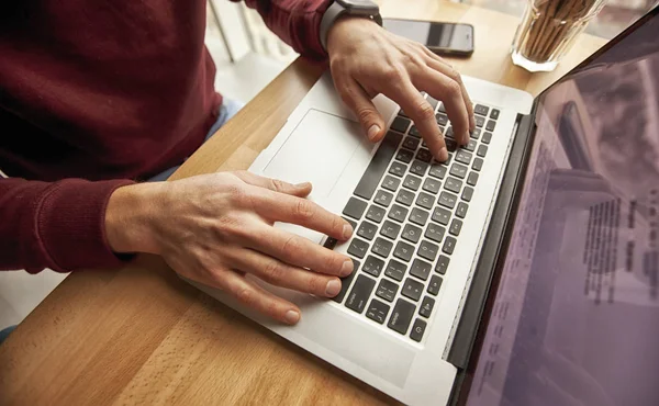 Een jongeman is bezig met zijn laptop — Stockfoto
