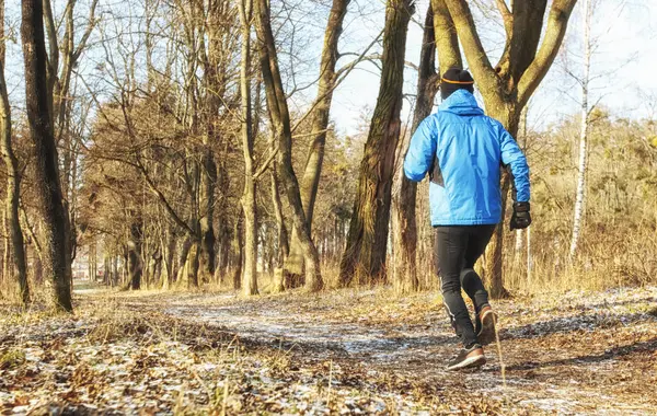 Il ragazzo sta facendo jogging nel parco invernale — Foto Stock