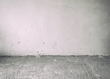 Eski ve kirli beton zemin ve gri duvar içeride terk edilmiş.