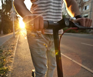 Genç adam elektrikli scooter üzerinde bile biniyor