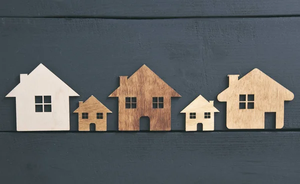 Cuatro casas de madera plana aisladas en la mesa oscura — Foto de Stock