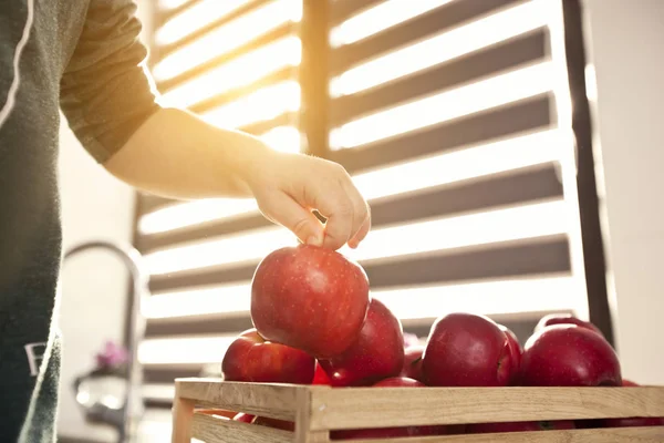Het kind neemt de sappige rode appel uit de mand met app — Stockfoto
