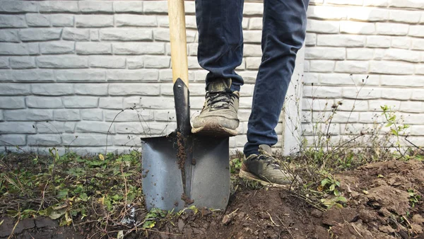 Человек копает почву в своем загородном доме — стоковое фото