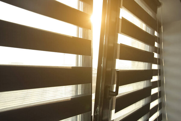 Sunlight enters the room through the blinds