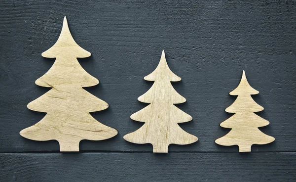Piękne tło świąteczne z trzema małymi drewnianymi dekoracjami — Zdjęcie stockowe