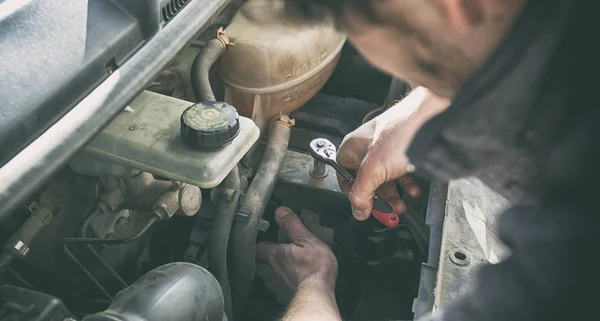 Adam evdeki bozuk eski arabayı tamir etmeye çalışıyor. — Stok fotoğraf