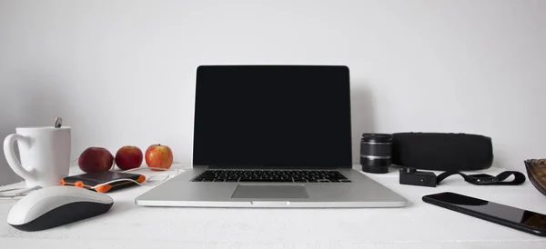 Espacio de trabajo en casa con portátil moderno en la mesa de madera y una l — Foto de Stock