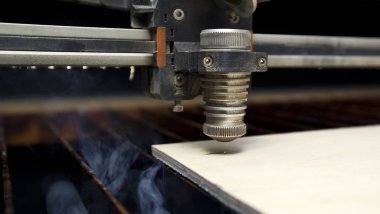 Lazer kesme makinesi tahta kesiyor.