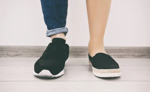 Dos tipos diferentes de zapatos en los pies de la mujer — Foto de Stock